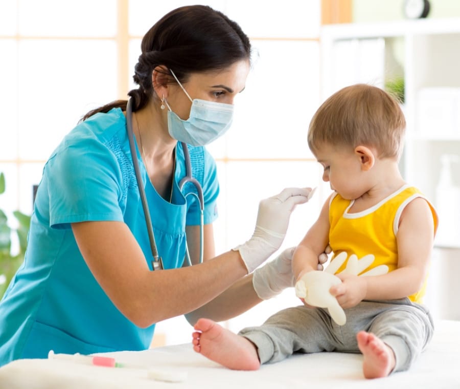 Una pediatra vaccina un bambino