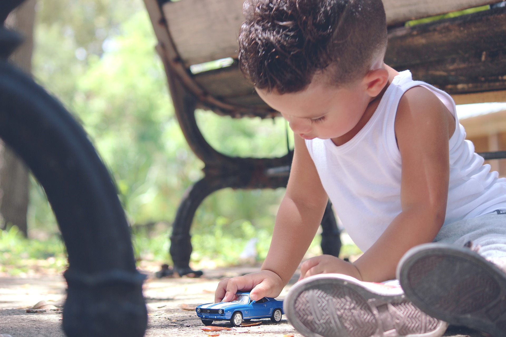 Un bambino mentre si diverte con un auto giocattolo.